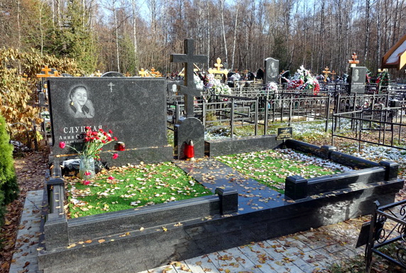 Широкий участок с прямоугольным надгробьем и православным крестом